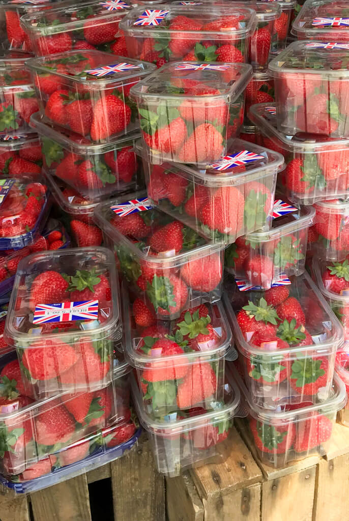 Punnets of bright red strawberries stacked outside a deli in London. Copyright@2024 Nancy Roberts