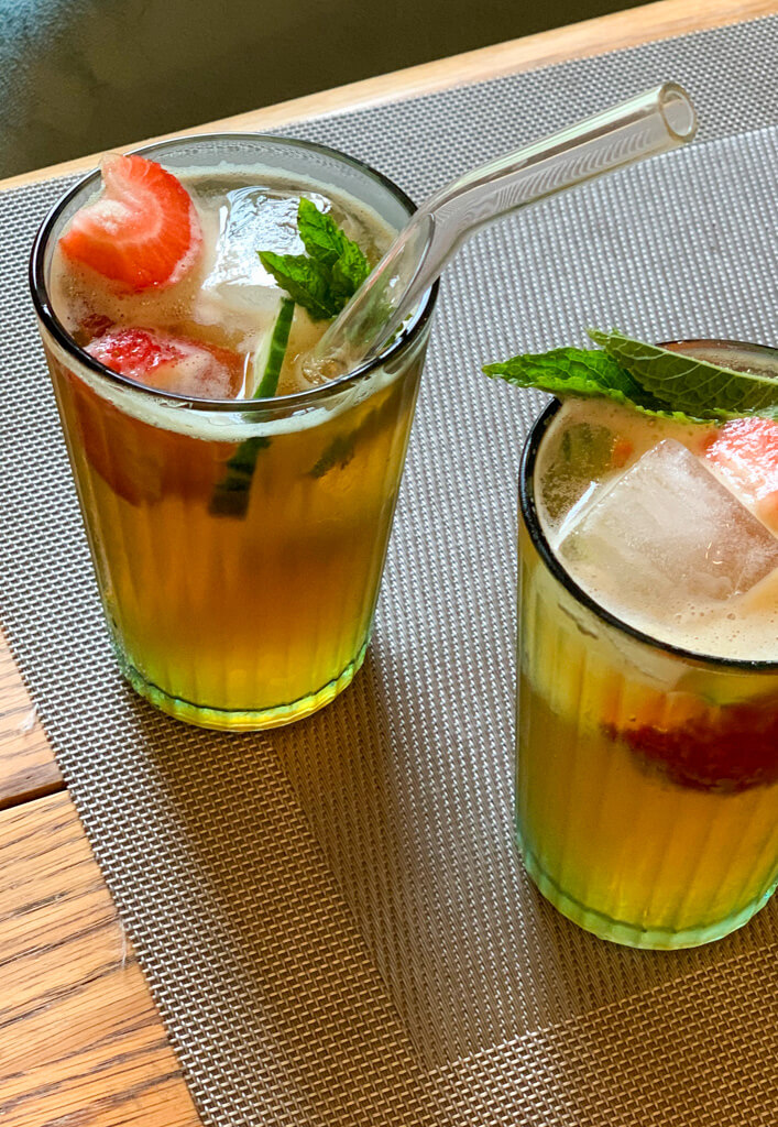 Two glasses of Pimm's garnished with strawberries and mint. Copyright@2024 Nancy Roberts