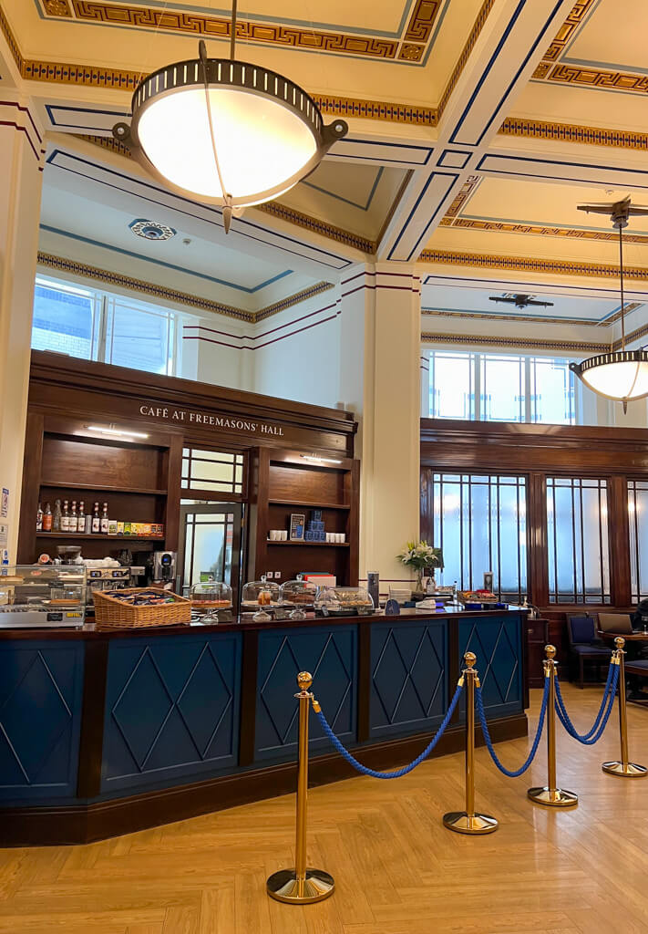 Traditional wooden panelled cafe counter in grand Art Deco room with coffered ceiling. Copyright@2024mapandfamily.com 