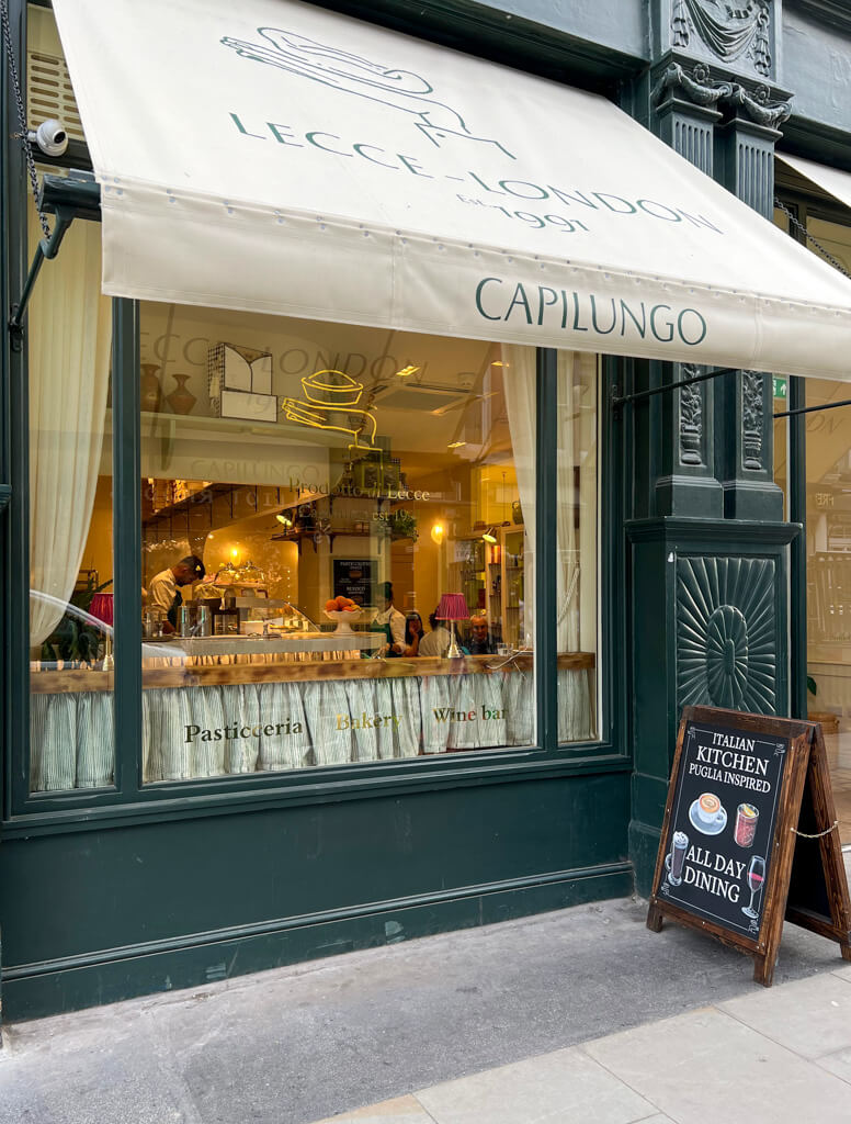Exterior of cafe in Covent Garden with white awning and advertising board outside. Copyright@2024mapandfamily.com 