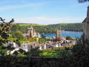 England countryside view of Fowey in Cornwall showing boats on the estuary with a the village and church in the foreground. Copyright@2025NancyRoberts