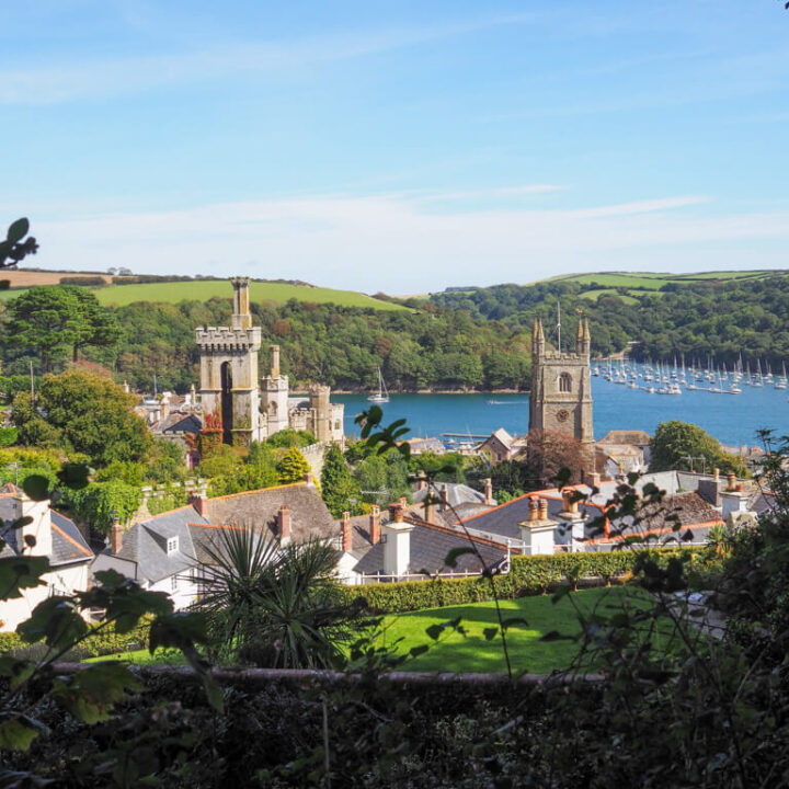 England countryside view of Fowey in Cornwall showing boats on the estuary with a the village and church in the foreground. Copyright@2025NancyRoberts