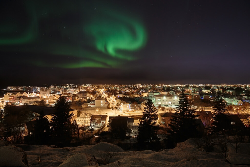 The Northern Lighs, a swirl of green on the night sky over Reykjavik. 