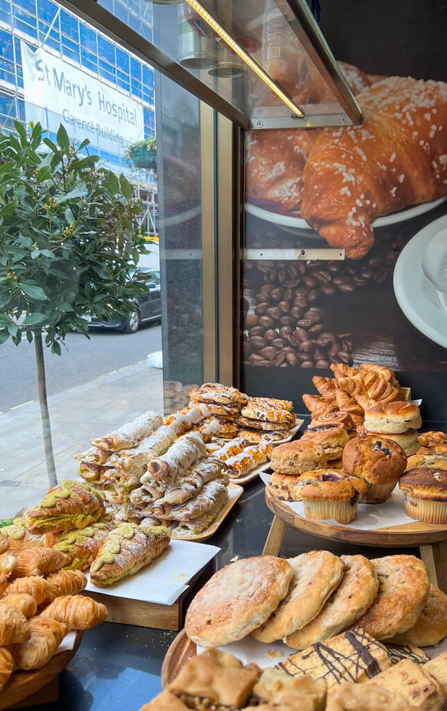 Stacks of cakes and pastries in the window of Bonne Bouche cafe in Paddington. Copyright@2024 mapandfamily.com
