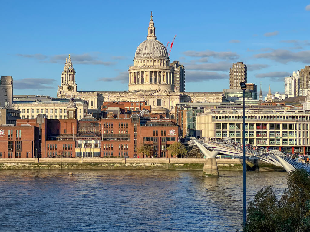 St Paul's Cathedral overlooking the Thames against a blue sky in London in November.  Copyright@2024 mapandfamily.com 