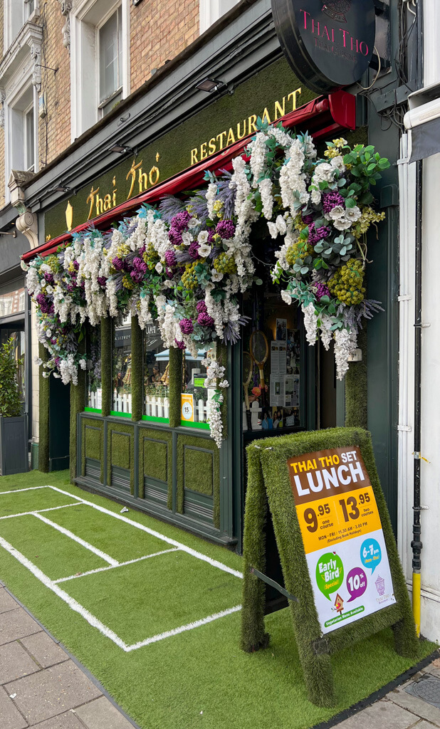 Exterior of Thai Tho restaurant in Wimbledon village decorated for the tennis championships with swags of flowers. Copyright@2024 Nancy Roberts