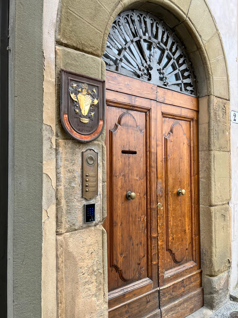 The heavy wooden doorway leading to the hotel from Piazza della Signoria. Copyright@2024NancyRoberts