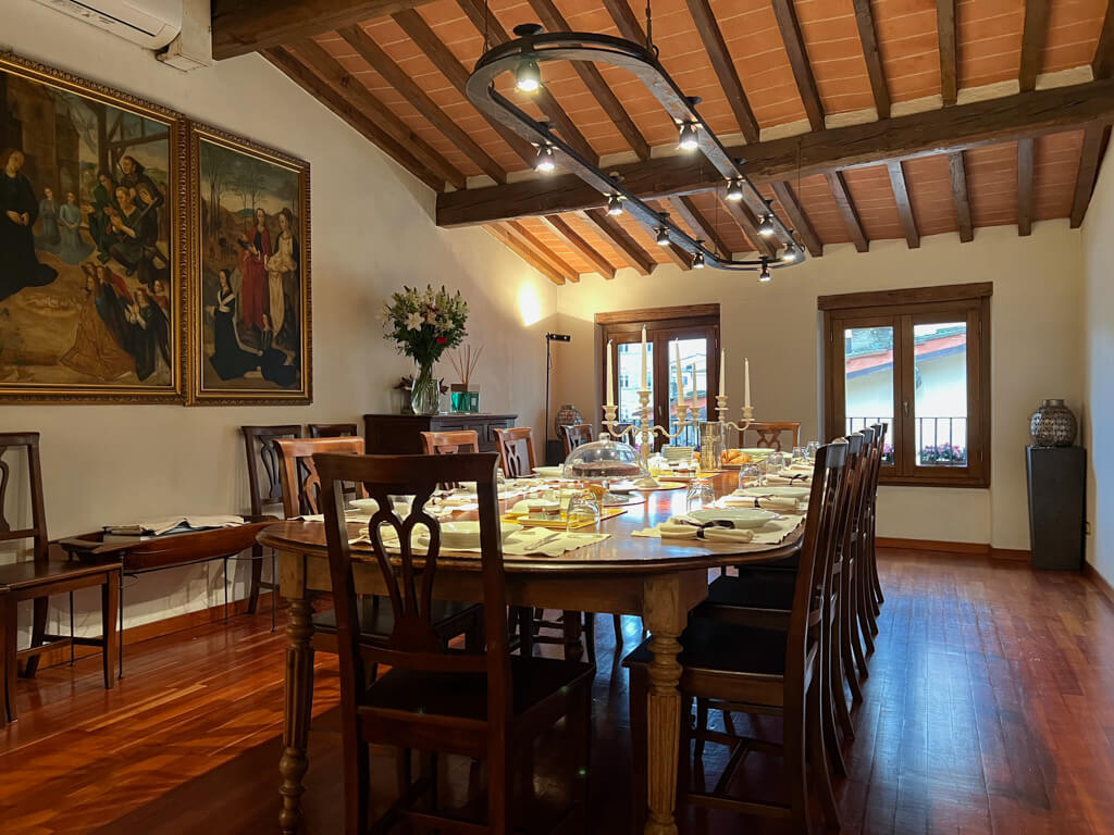 The breakfast room at Hotel In Piazza della Signoria has a long polished antique table surrounded by chairs and laid with glittering silverware, napkins and candelabra.Copyright@2024 NancyRoberts 