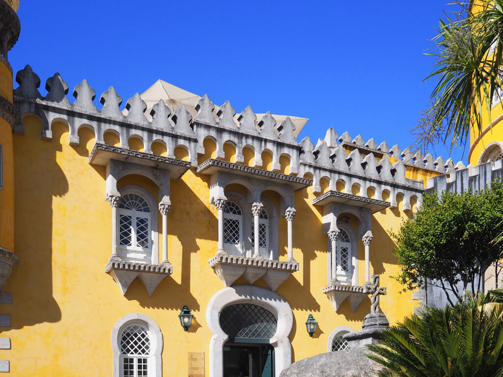 Bright yellow castellated walls and windows in Pena Palace, one of the best places to visit in Sintra. Copyright@2025 NancyRoberts