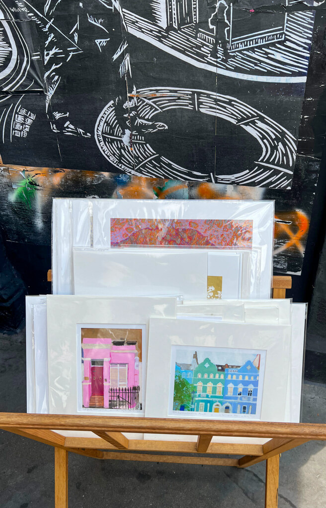 A selection of prints on a stand on the pavement outside an art gallery. Copyright@2025 NancyRoberts