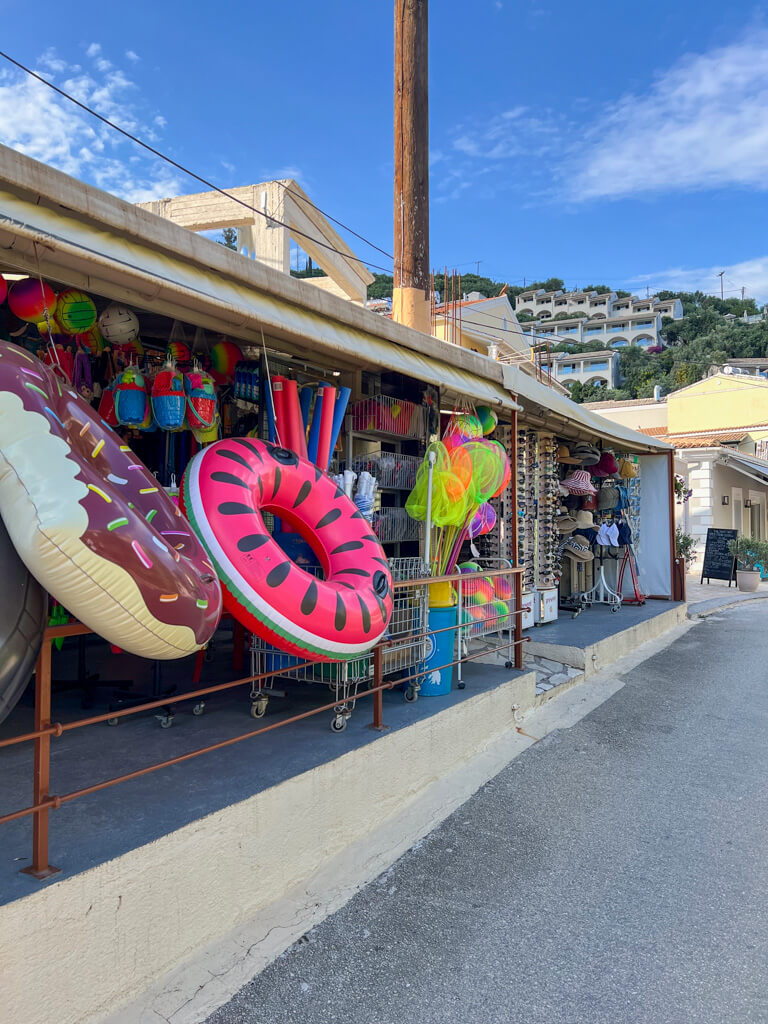 Colourful beach toys hanging from the verandah of a small shop in Kalami village. Copyright@2025 NancyRoberts