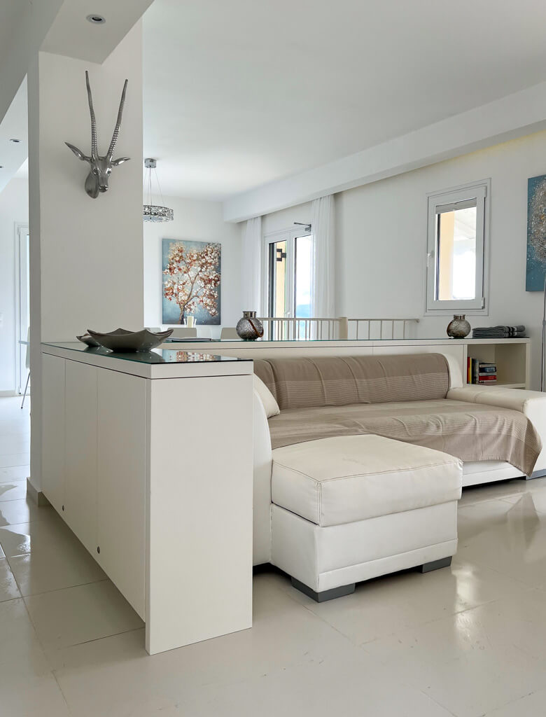 Villa Bliss Kalami ground floor with white sofa with throw and white storage units. Copyright@2025NancyRoberts