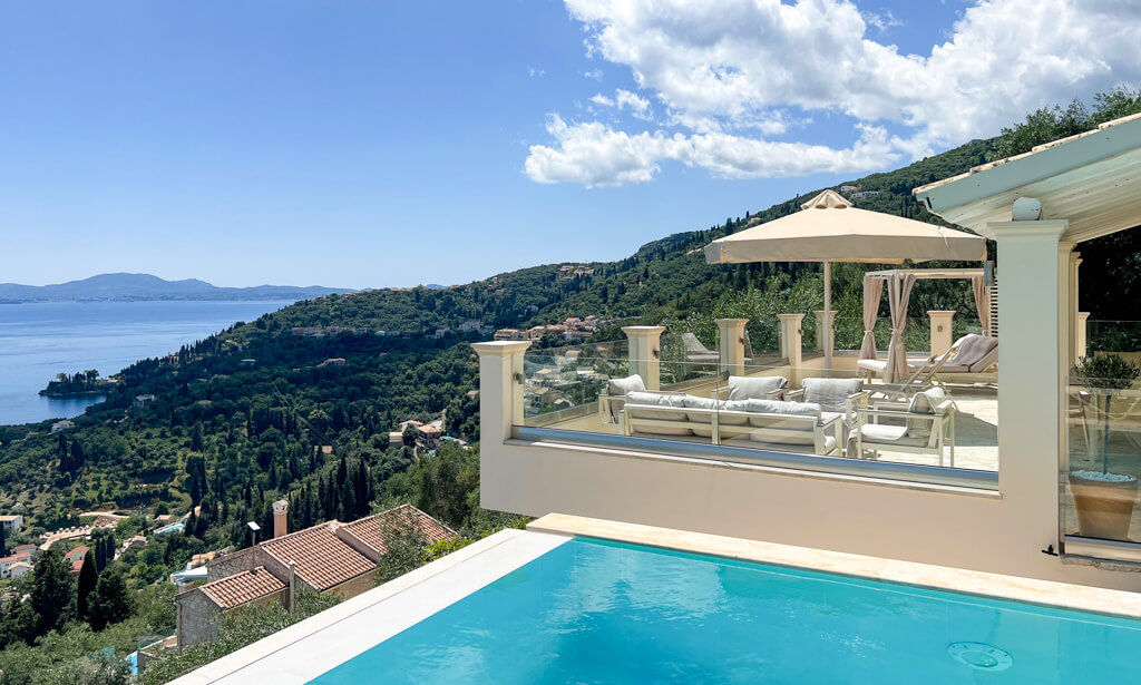 View of Villa Blliss in Kalami terrace and pool with hillside and sea in background. Copyright@2025NancyRoberts