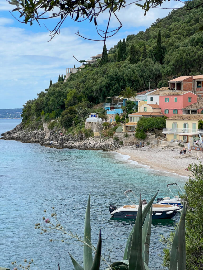 Pastel coloured buildings looking out to sea at Kaminaki beach near Kalami, Corfu. Copyright@2025 NancyRoberts