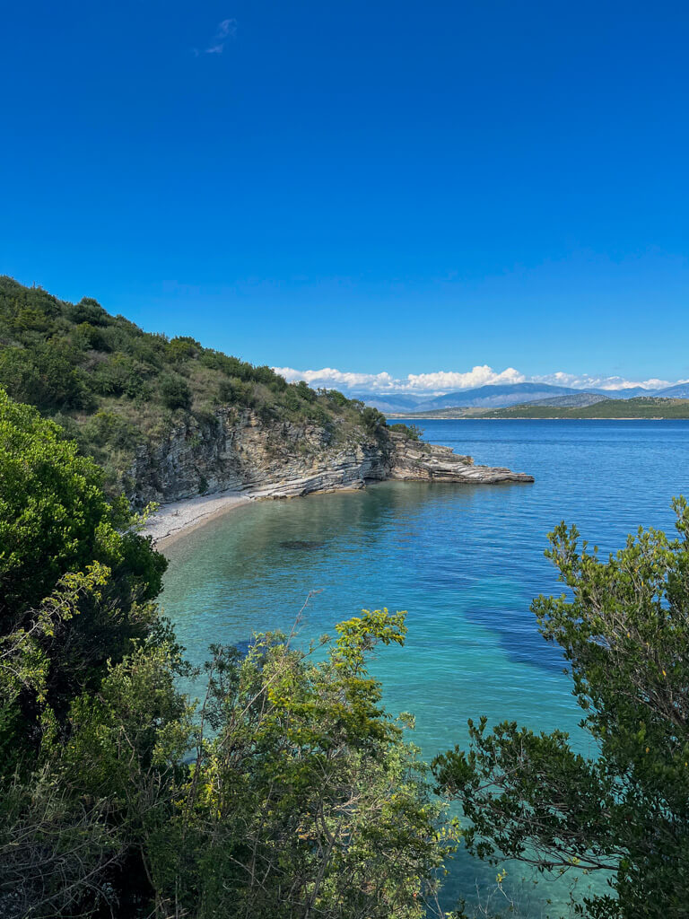 An empty beach on the coast path and views of the Albanian coast. Copyright@2025 NancyRoberts