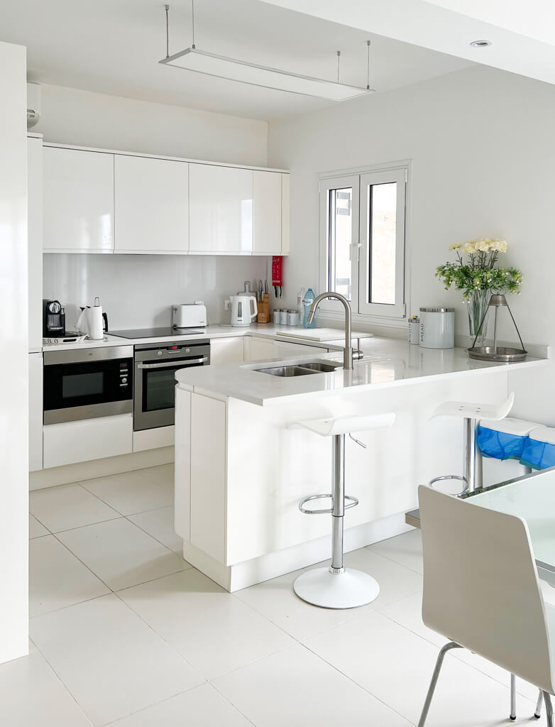 Kitchen area with white gloss units and breakfast bar Copyright@2025NancyRoberts