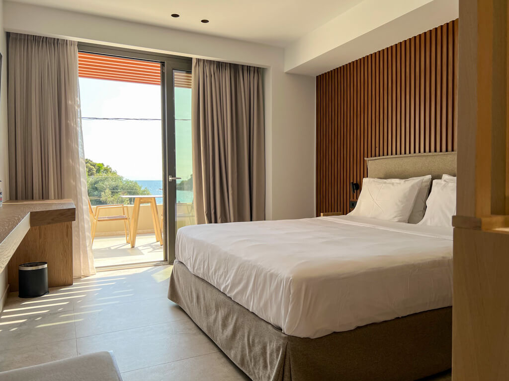 Comfortable queen-sized bed and dontemporary decor in natural wood tones. Copyright@2025 NancyRoberts