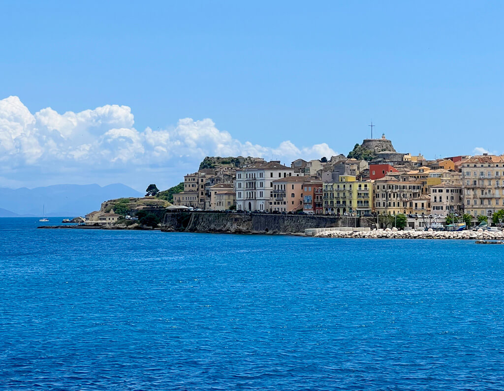Ferry from Corfu to Sivota with view of Corfu Town's colourful buildings and fortress. Copyright@2025 NancyRoberts