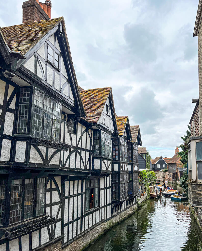 Canterbury Dover from London: the medieval black and white facade of the Weaver's House overlooks the river in Canterbury. Copyright@2025 Nancy Roberts