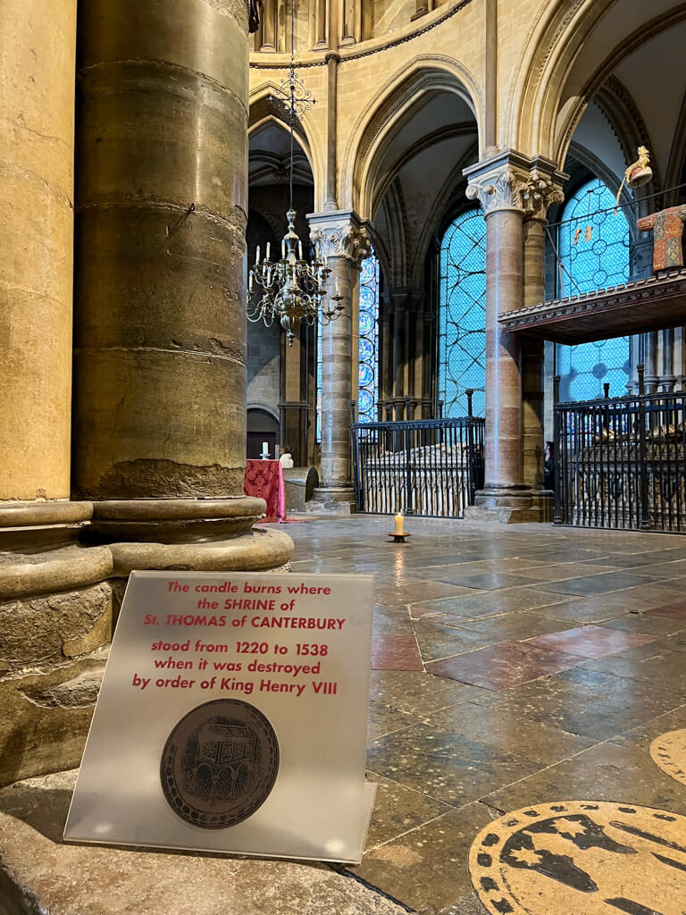 A candle flickering on the stone floor of the nave of Canterbury Cathedral. Copyright@2025 Nancy Roberts