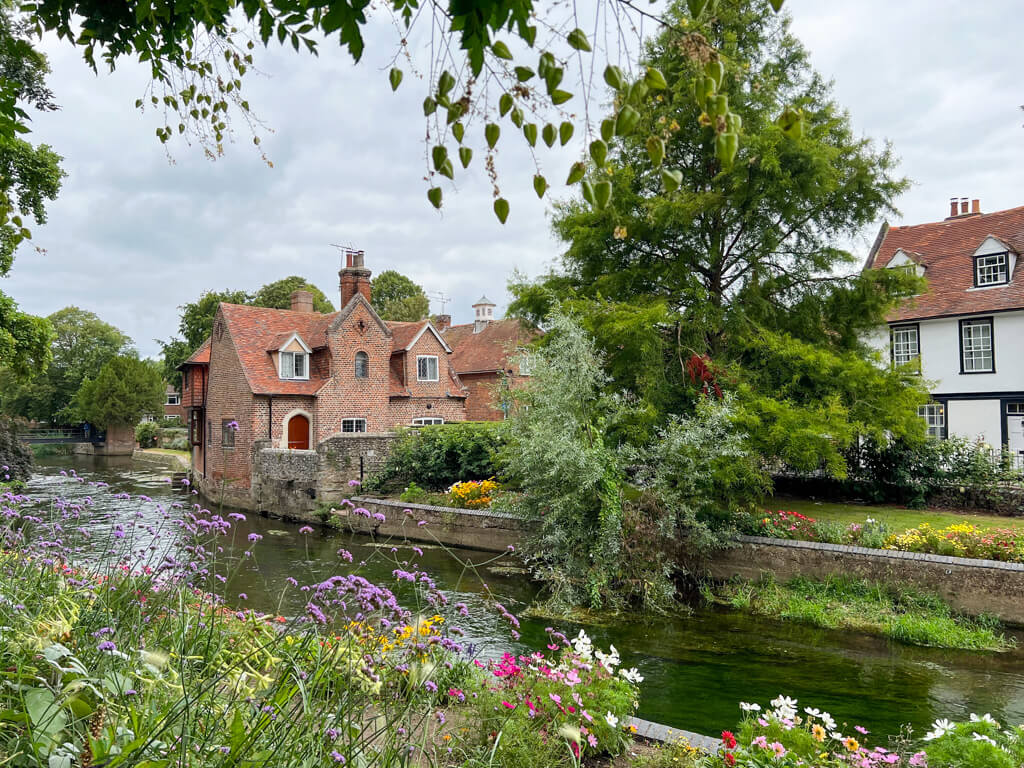 A view of the River Stour running through the city of Canterbury with summer flowers in the bankside gardens. Copyright@2025 Nancy Roberts